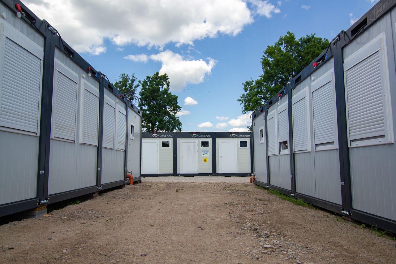 Photo of modern office containers with shutters under a blue sky.