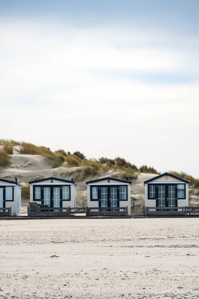 Idyllic beach cottages nestled by sandy dunes, perfect for summer retreats.